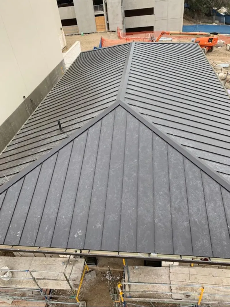 Commercial metal roof construction with crane equipment in Waite Park